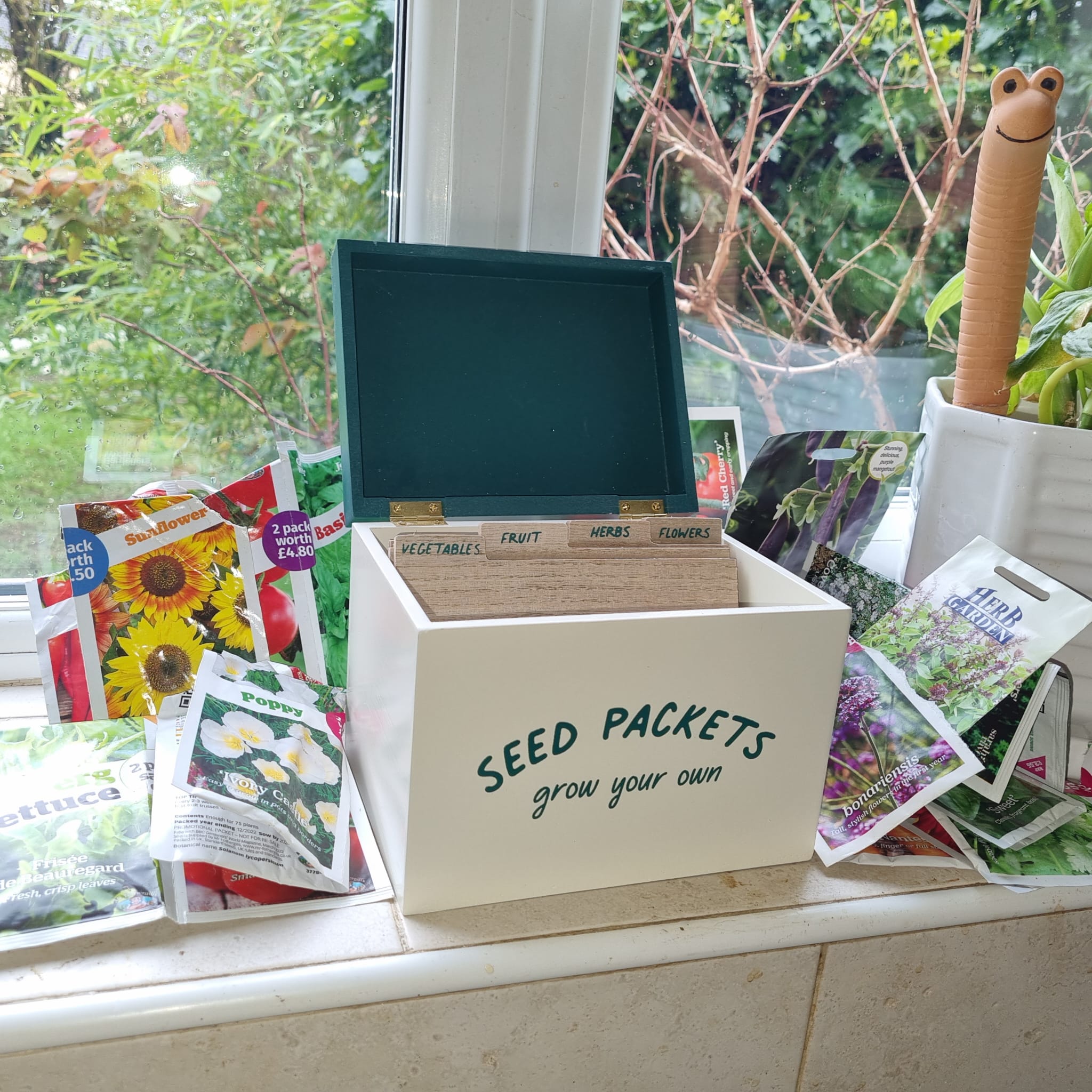 seed box cream on windowsil with seed packets